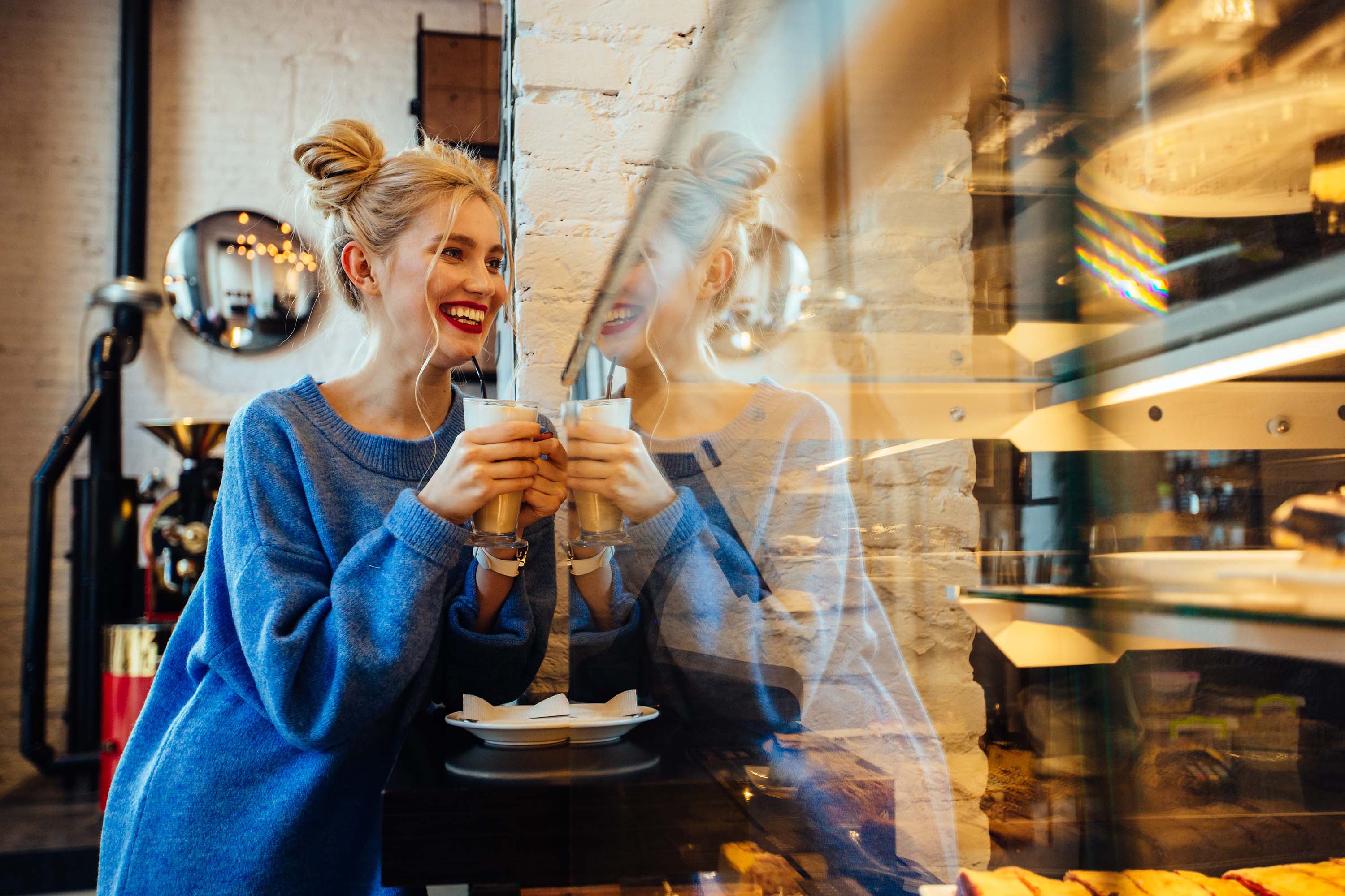 Frau trinkt einen Cappuccino in einem Café, explore unique Hotels 