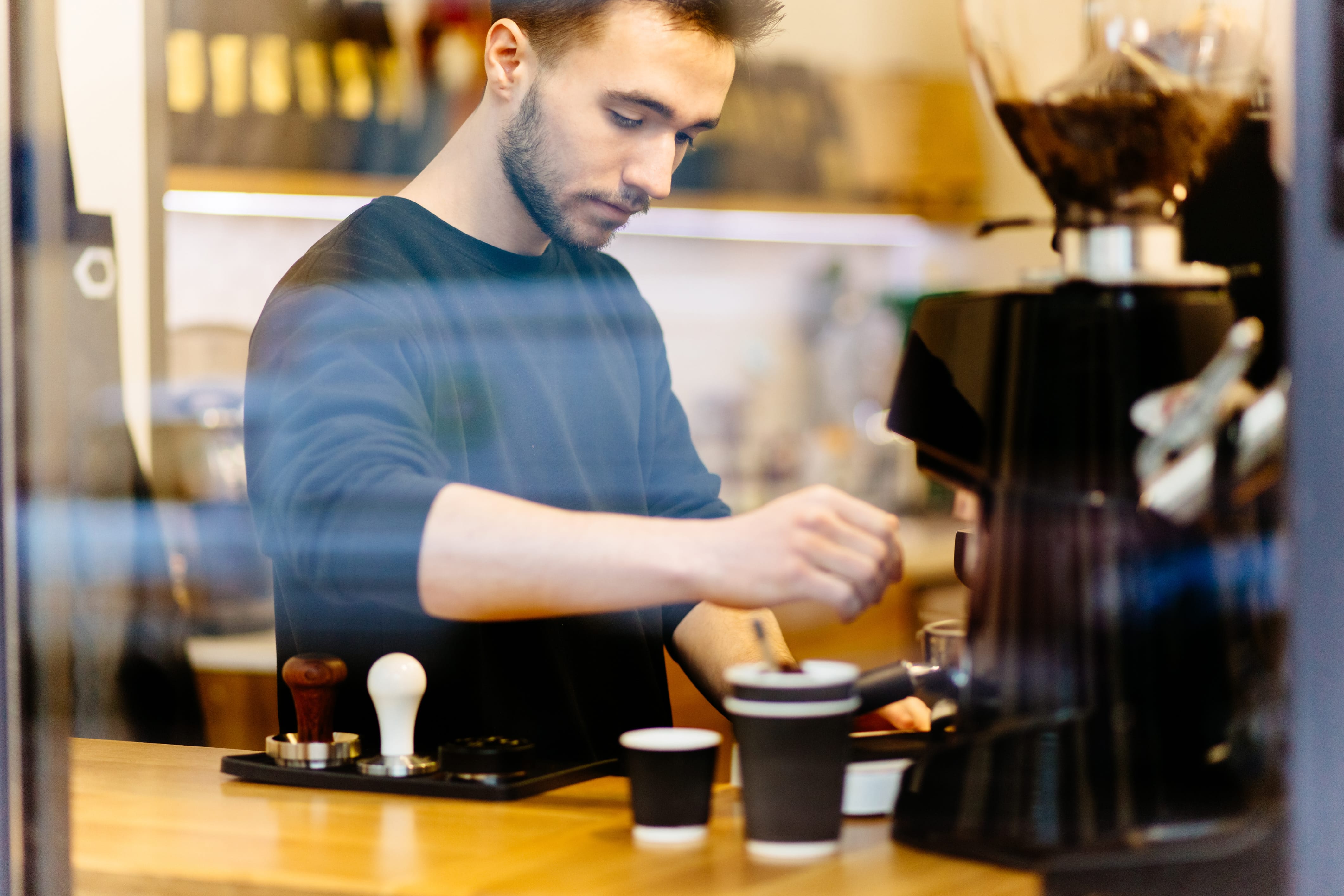 Mann Barista macht einen Cappuccino in einem Café, explore unique Hotels 