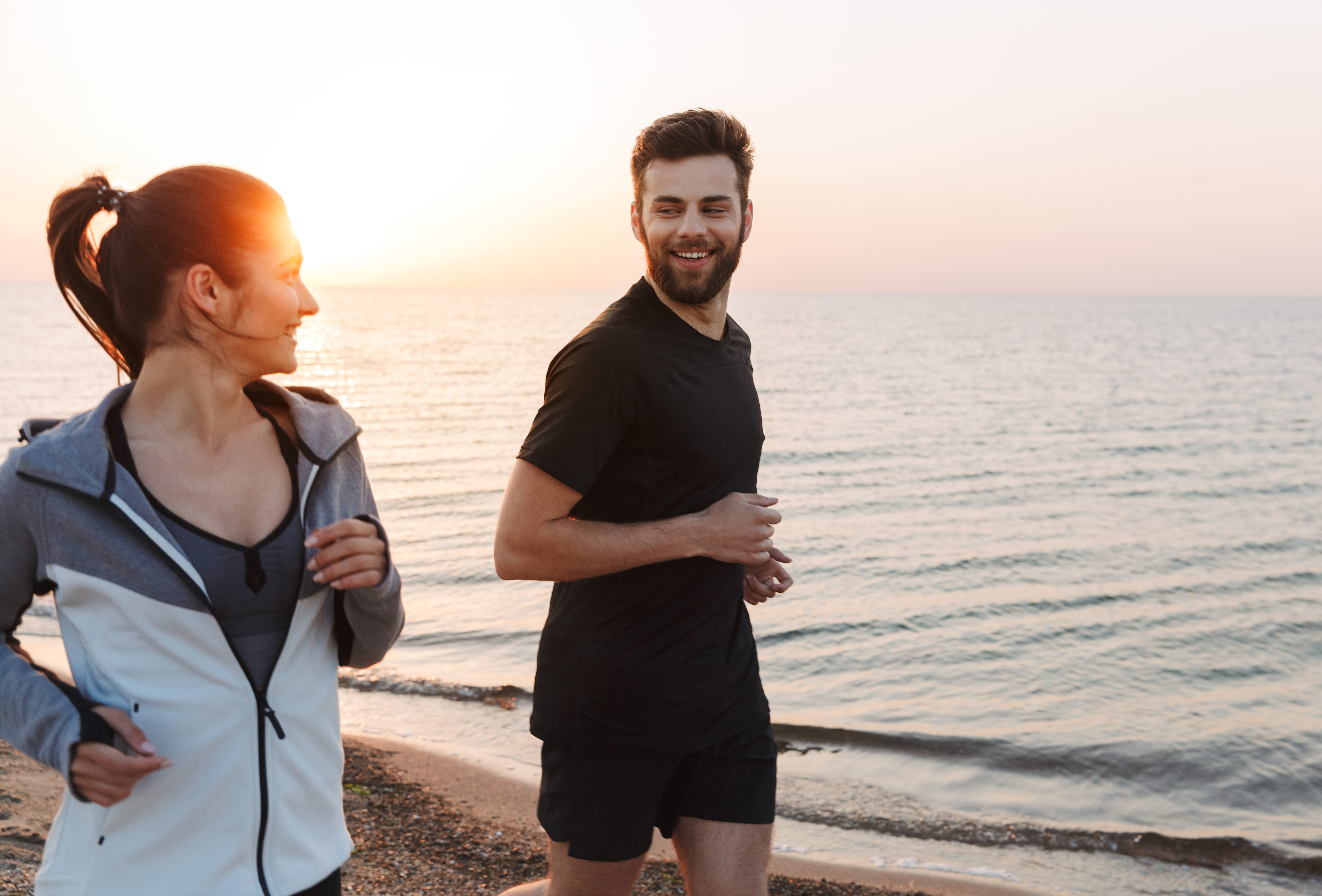 Paar geht joggen am Strand, explore unique Hotels 