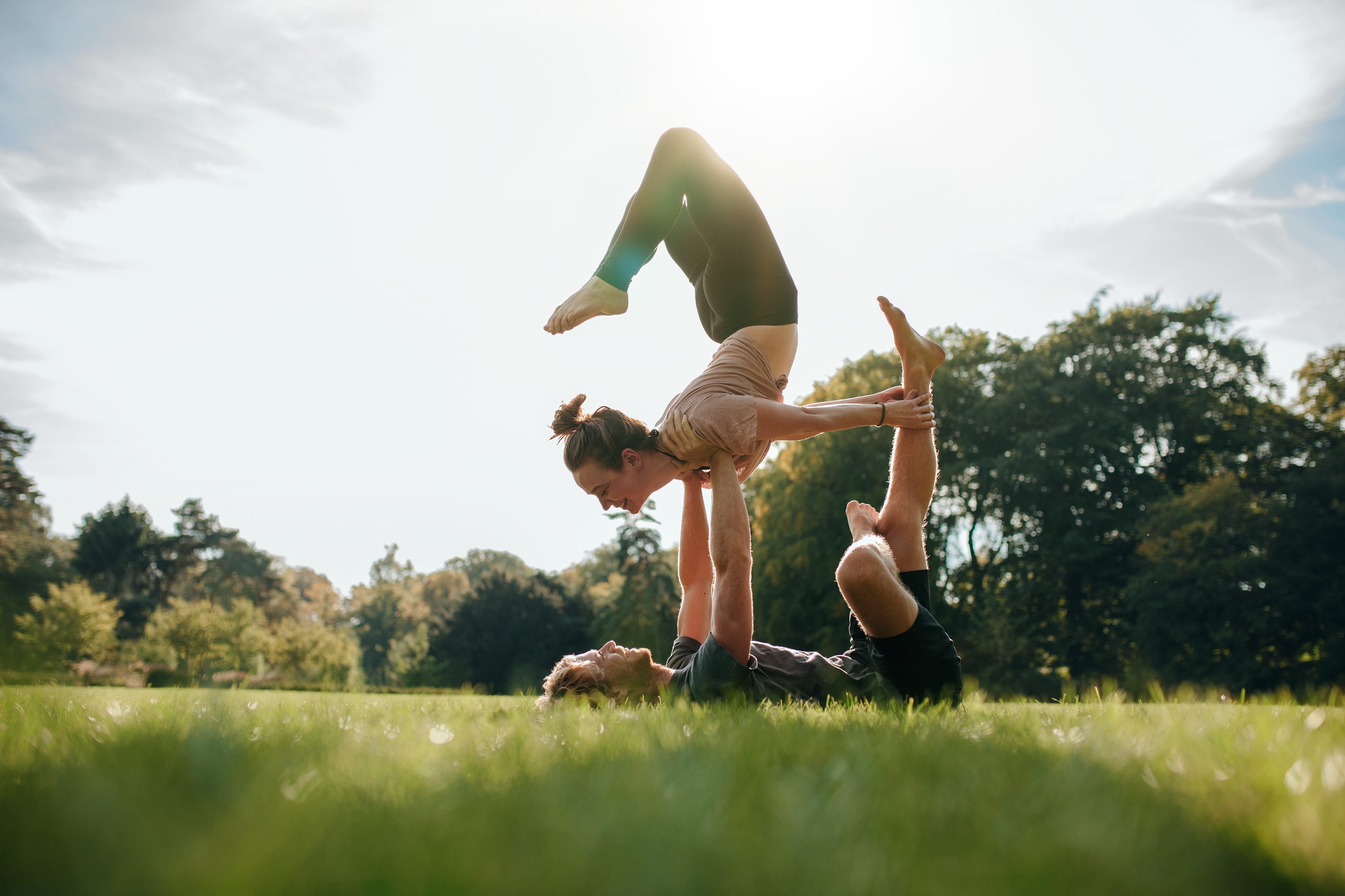 Mann und Frau machen Yoga im Park, explore unique Hotels 