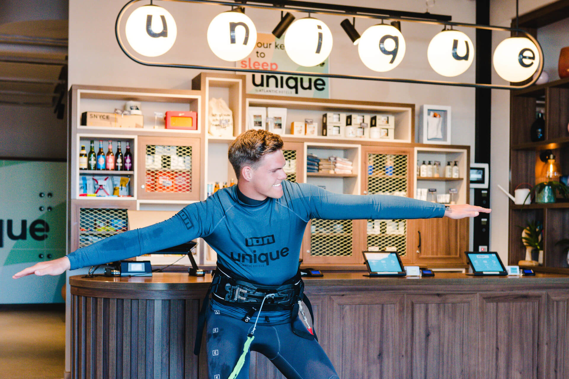 Surfer Jendric Burkhardt im Neoprenanzug im Foyer | unique by ATLANTIC Hotels Kiel