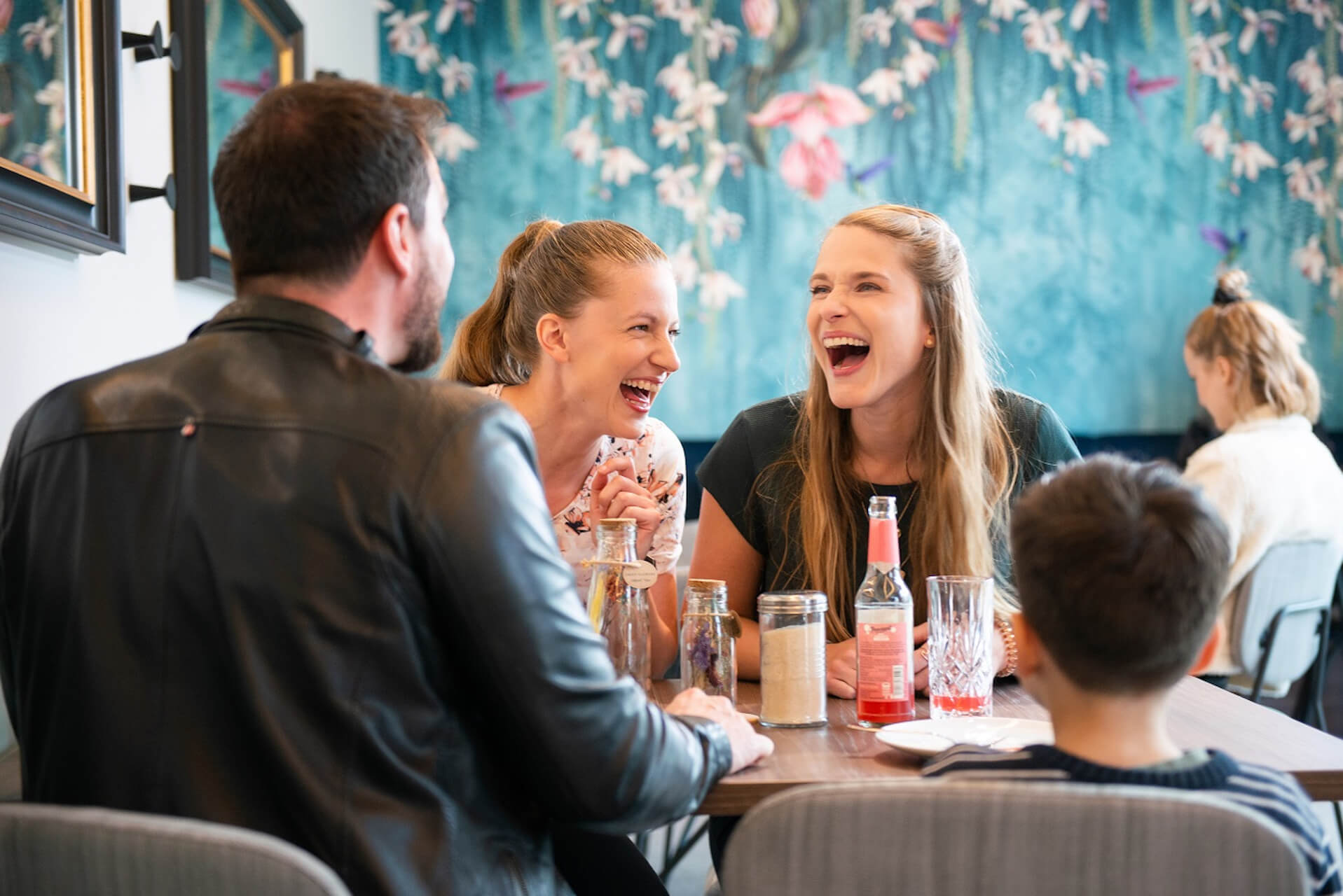 Menschengruppe lachen im Café RESTEZ! im unique by ATLANTIC Hotels Kiel