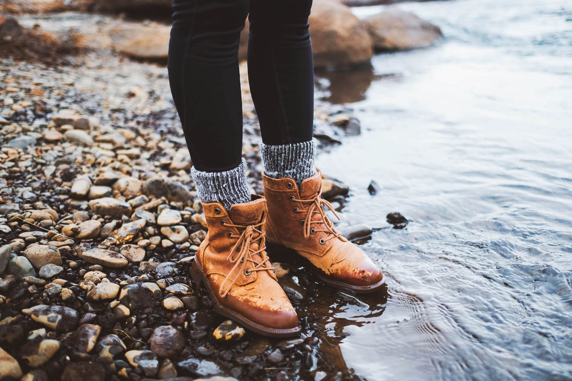 Woman standing with shoes in the sea on the beach in Kiel | unique by ATLANTIC Hotels Kiel