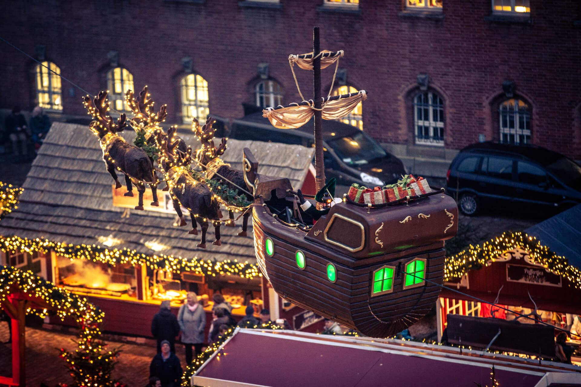 Schlitten und Rentiere fliegen über eine Bude auf einem Weihnachtsmarkt in Kiel Weihnachtsmärkte in Kiel