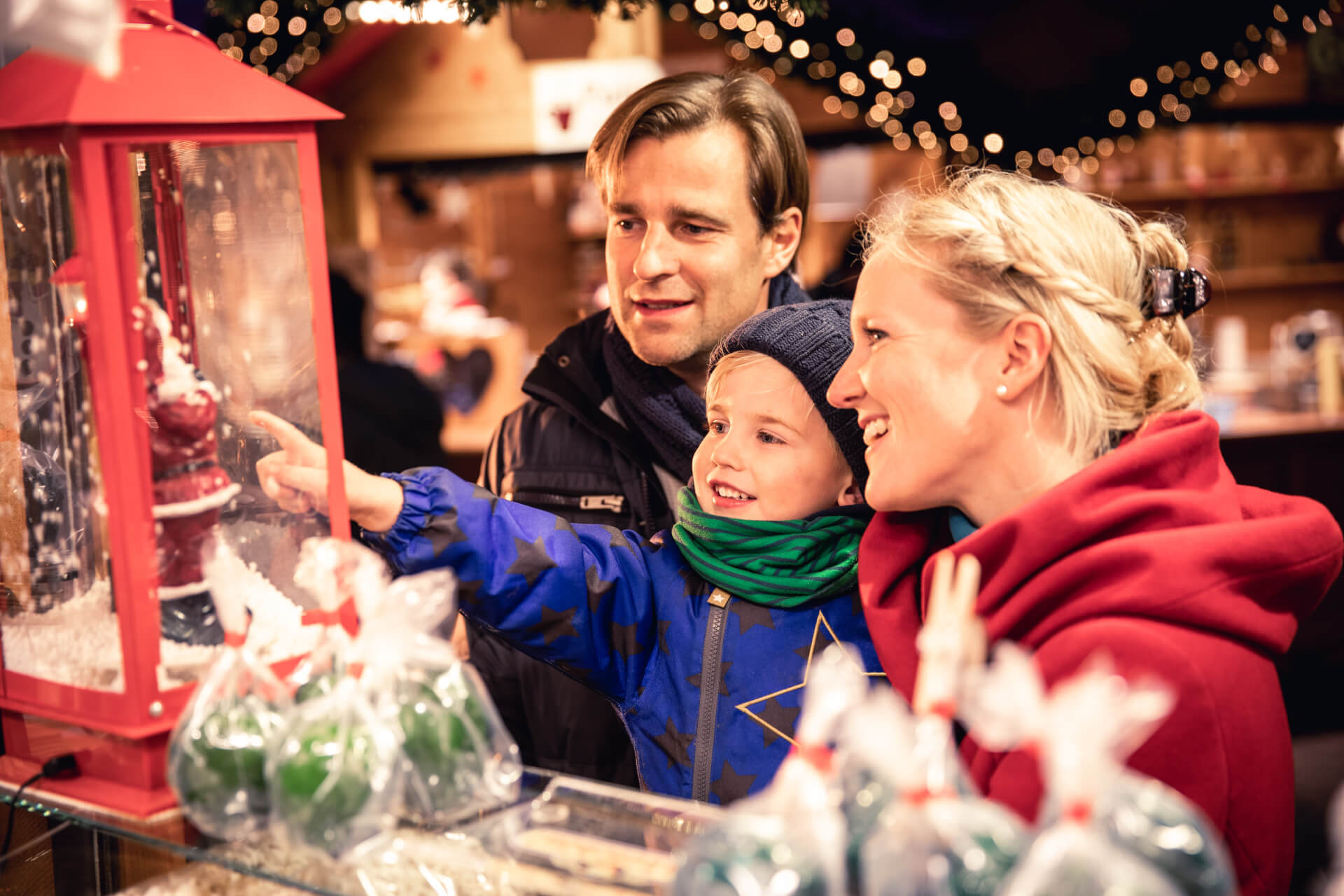 Kind schaut sich mit Eltern eine Weihnachtsmann-Lampe an Weihnachtsmärkte in Kiel | Vergnügen für die ganze Familie