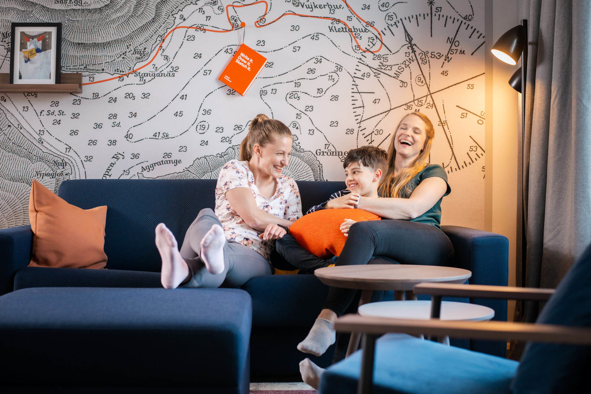 Family on sofa in the studio of the unique by ATLANTIC Hotel Kiel